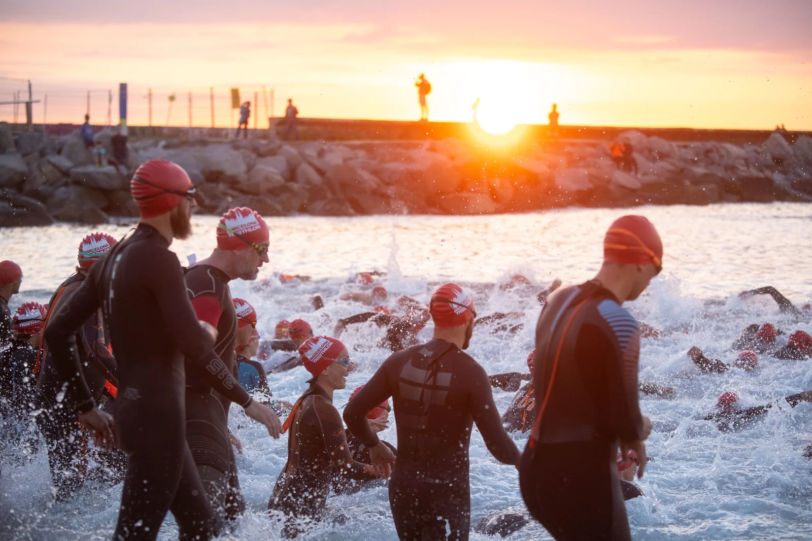 Participantes del Barcelona Triathlon entrando al mar al amanecer